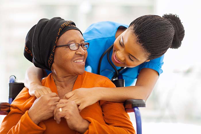 nurse hugging a wheelchair bound woman